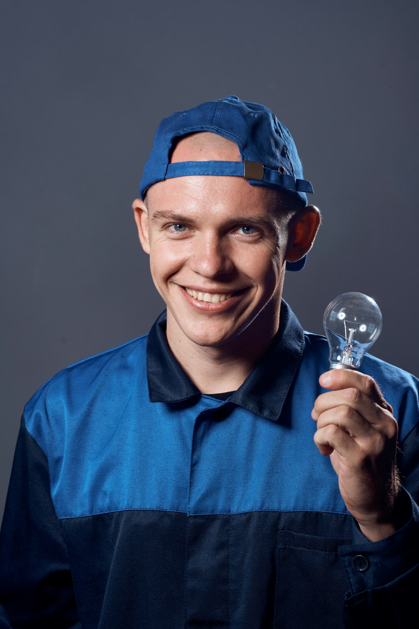 working man in uniform with a lamp in his hands electrician profession